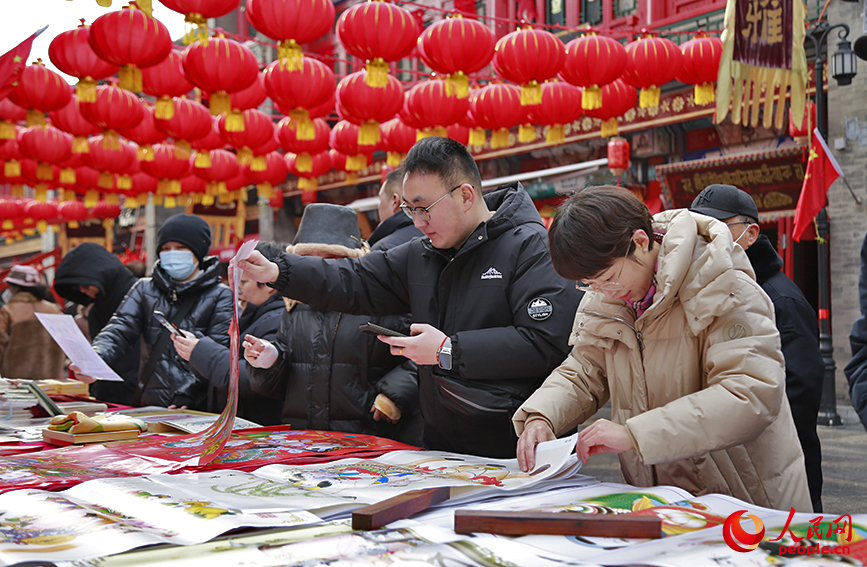 市民在大集摊位前挑选年画。人民网记者 崔新耀摄