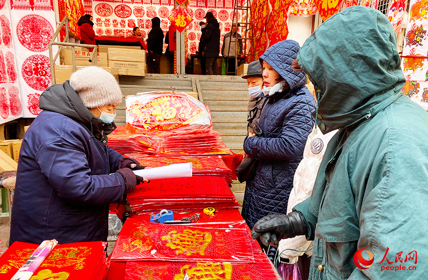 天津市大胡同年货市场人气旺，市民挑选采购心仪的年货商品。人民网记者 唐心怡摄